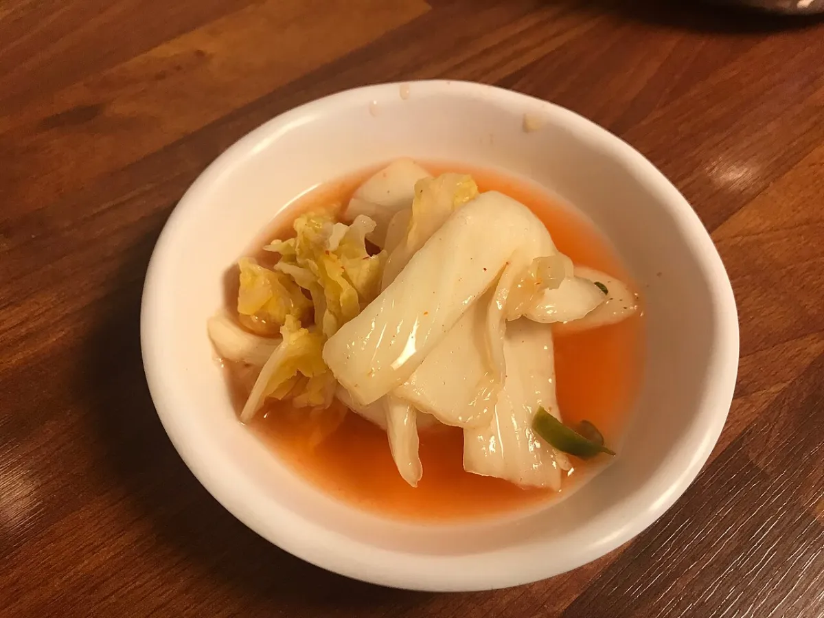 White kimchi in a bowl of clear brine