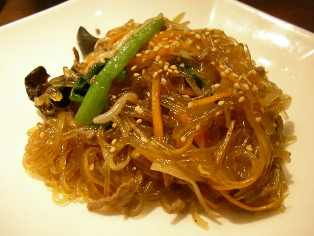 A plate of japchae: glass noodles stir-fried with vegetables and sesame seeds
