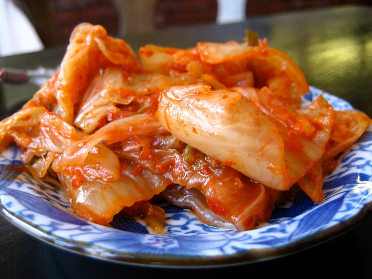 Napa cabbage kimchi on a blue and white plate